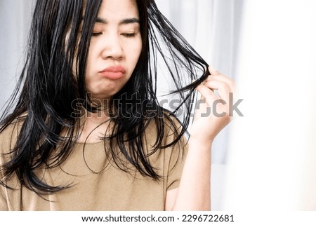 close-up of Asian woman's hair issues with oiliness and thinning Royalty-Free Stock Photo #2296722681