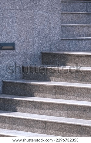 Sunlight and shadow on steps surface of gray marble staircase in entrance building area and vertical frame