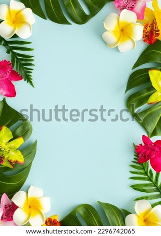 Summer background with tropical orchid flowers and green tropical palm leaves on light background. Flat lay, top view. Summer party backdrop Royalty-Free Stock Photo #2296742065