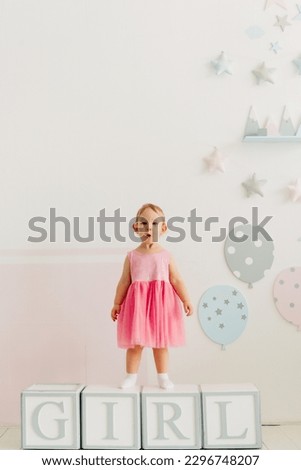 concept of children's emotions. Portrait of lovely toddler little baby child with pink dress	