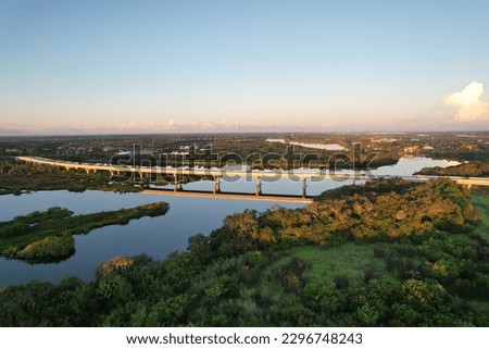 The view of Fort Hamer Bridge and trees under the blue sky reflected in the water