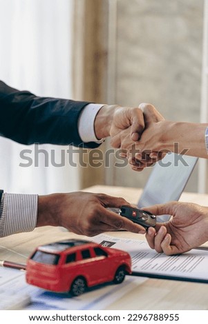 The salesman shakes hands with the customer, after signing the contract and completing the payment, the sales manager offers to sell the car and explain the insurance terms in the office.
