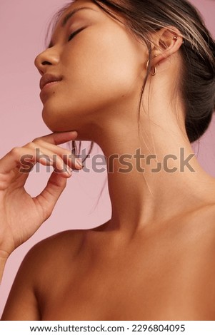 Close-up of a beautiful woman with clean and clear skin. Asian female model with hand on chin and eyes closed. Royalty-Free Stock Photo #2296804095