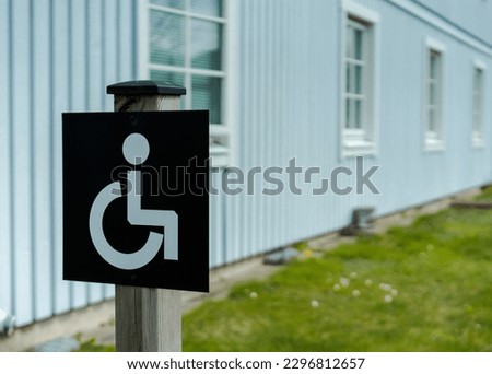 Disabled sign in front of building. Sweden. Handicapped wheelchair access symbol.