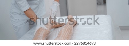 Woman enjoying procedure of legs massage in spa salon. Beauty concept