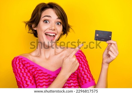 Photo of impressed astonished nice girl dressed off shoulder shirt staring directing at debit card isolated on yellow color background