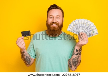 Photo of success irish businessman wear green t-shirt hold much money dollars wireless payment debit card income isolated on yellow color background