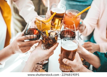 Close up image of hands holding cocktail glasses at bar restaurant - Young people having fun hanging out on weekend day - Food and beverage concept with guys and girls drinking alcohol together 