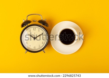 Good morning coffee and alarm clock concept on bright colored background.Top view.Good morning concept. Invigorating hot espresso.