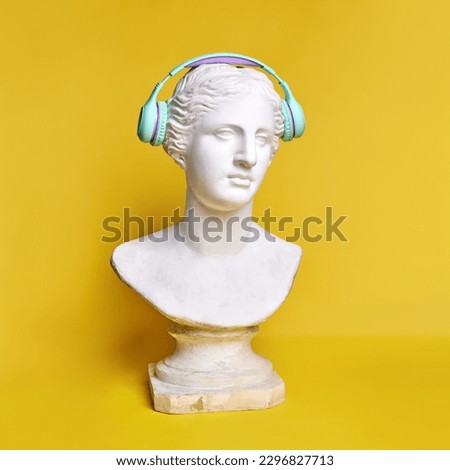 Antique statue bust wearing blue headphones against yellow background. Music lifestyle, technologies, relaxation. Concept of creativity, modernity and vintage, antique art. Inspiration and imagination