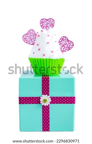 meringue cupcake with pink hearts on a mint green gift box on white background