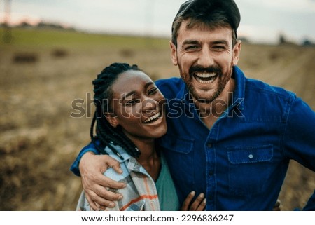 Close up portrait of a diverse couple looking and smiling towards the camera while spending a day outdoors. Lifestyle concept
