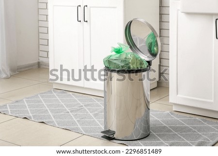 Full trash bin in interior of modern kitchen Royalty-Free Stock Photo #2296851489