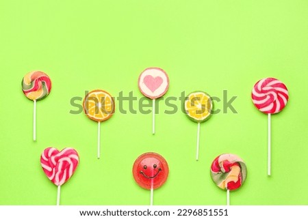 Composition with different lollipops on green background