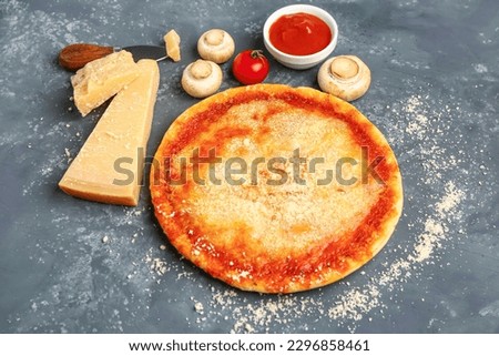 Tasty pizza with parmesan cheese and sauce on blue grunge background
