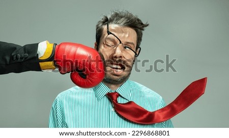 Mature businessman in red tie getting boxing punch in jaw from business competitors. Concept personal challenge, financial loses, business fall, deadlines, economic crisis, bad investment. Sport, ad Royalty-Free Stock Photo #2296868801