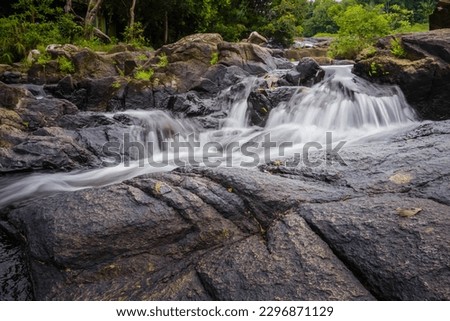Long exposure photography of Mountain river flowing through the green forest at Air Temurun Waterfall in Anambas, Indonesia. Green forest at spring time. Concept for world water day, save water.