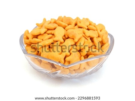 A scattering of yellow fish crackers on white background  Royalty-Free Stock Photo #2296881593