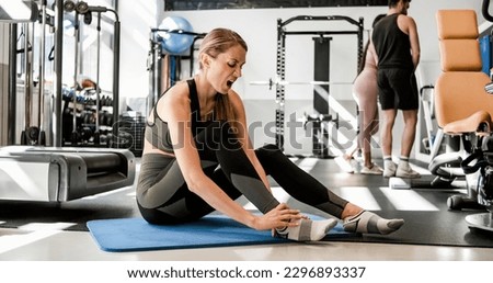Sad woman suffering from pain during workout Royalty-Free Stock Photo #2296893337