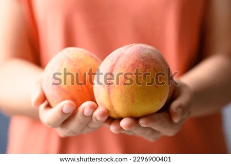 Ripe Peaches fruit holding by woman hand Royalty-Free Stock Photo #2296900401