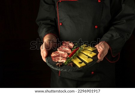 The cook is holding a serving plate with an appetizer of ham and cheese. The concept of serving food by the waiter. Free space for recipe or menu.