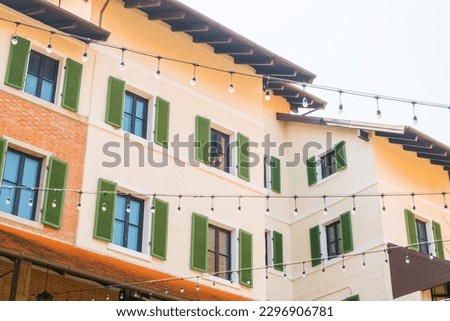 Red brick wall of a modern building with windows in old urban alley.