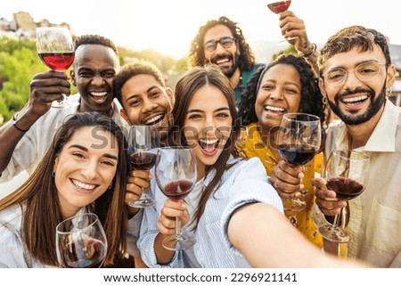 Multiracial friends drinking red wine outside at farm house vineyard countryside - Group of young people taking selfie picture outdoor - Life style concept with guys and girls enjoying summer vacation Royalty-Free Stock Photo #2296921141