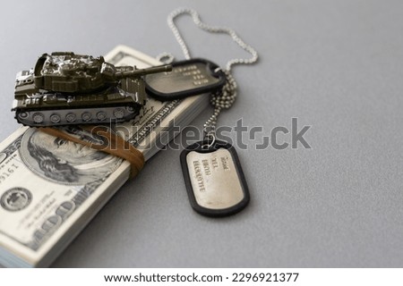Army identification medallions and dollar bills on United states flag. Military pension, salary in the army or military insurance Royalty-Free Stock Photo #2296921377