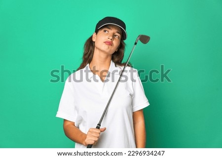 Young caucasian golfer holding a golf stick isolated Young caucasian goltouching back of head, thinking and making a choice.