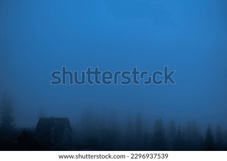 old wood house in the dark fog in mountains landscape