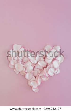 Valentine's Day concept. Heart made of pink rose flower petals on pastel pink background. Flat lay, top view