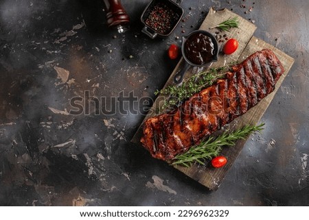 Spicy rack of spare ribs with marinade on a wooden board, banner, menu, recipe place for text, top view. Royalty-Free Stock Photo #2296962329