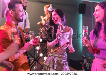 Group of people dancing in the club with DJ in background