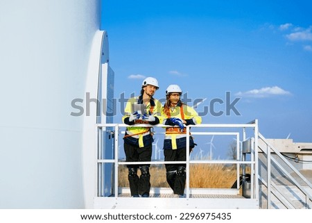 Technicians team with safety uniform working at wind turbine field
