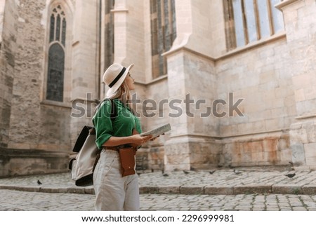 Young woman travel alone in old city centre. Wide photography.