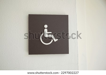 Restroom sign with figures of a girl, guy, and handicap symbol depicts gender and accessibility. The girl and guy figures indicate separate restrooms for men and women
