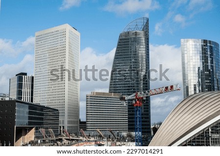 Skyscrapers of La Defense modern business and financial district in Paris with highrise buildings and convention center. Crane and building construction. Blue cloudy sky Royalty-Free Stock Photo #2297014291