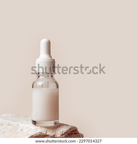 Glass dropper bottle with extract coconut or serum on stand from natural stones on beige background. Natural Organic Spa Cosmetic concept, cosmetic product mock up, minimal style. Side view, copyspace Royalty-Free Stock Photo #2297014327