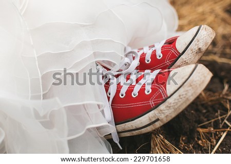young bride in dirty red plimsolls on ground
