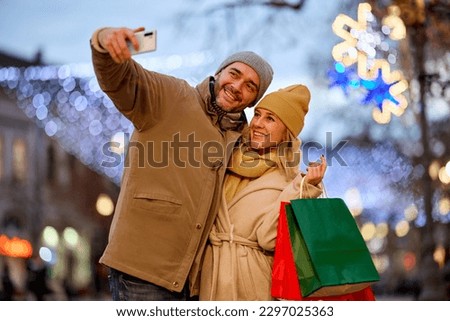 Mid adult couple taking Selfie with smart phone while out shopping