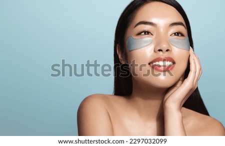 Woman applying golden eye patches. Close up portrait girl. Young woman applying collagen patches under eyes, taking care of delicate skin around eyes. Royalty-Free Stock Photo #2297032099