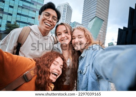 Smiling multi-ethnic university students taking selfie on erasmus Europe. Happy friends photo together outside university campus smiling. Cheerful young people classmates pose and have fun.