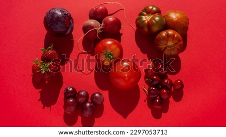 overhead photo of monochromatic red vegetables and fruits, spaced still life distributed by products.