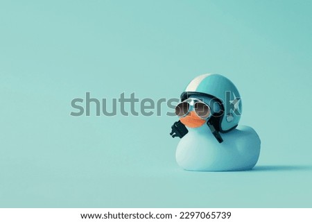 Creative composition made of blue cute little rubber duckling with a helmet and sunglasses on blue background.Summer minimal duck concept. Creative art, Contemporary style.Writing space, copy space.