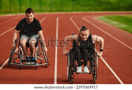 An inspiring couple with disability showcase their incredible determination and strength as they train together for the Paralympics pushing their wheelchairs in marathon track  Royalty-Free Stock Photo #2297069917