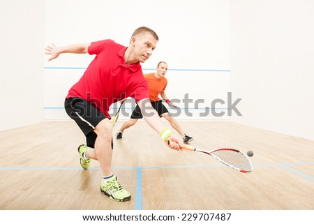 Two men playing match of squash. Closeup of squash players in action on squash court  Royalty-Free Stock Photo #229707487
