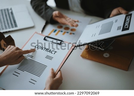 the buyer is signing a contract to business people calculating interest, taxes and profits to invest in real estate and home buying with mock up tablet and calculator.