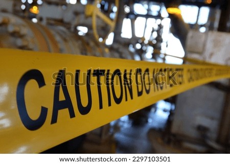 barricade tape saying caution do not enter in oil and gas facility