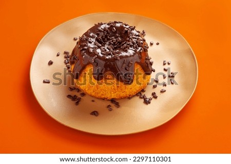 Carrot cake on orange background.  Mini volcano cake with chocolate topping and chocolate sprinkles isolated on orange background