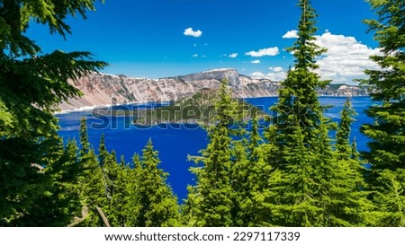 Beautiful Crater Lake National Park with late season snow still lingering into early summer. Bright blue lake with reflections Royalty-Free Stock Photo #2297117339